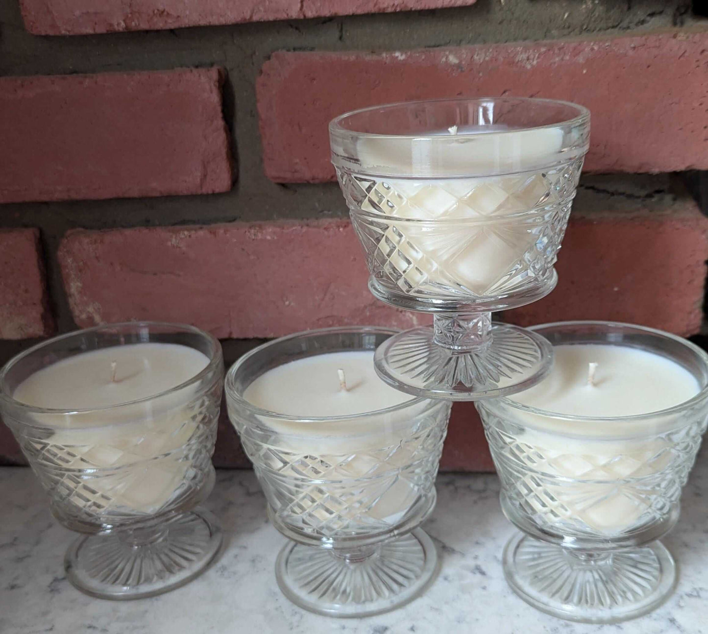 Set of four hand-poured unscented candles in elegant pressed glass, showcasing coco-soy wax blend, perfect for home decor.