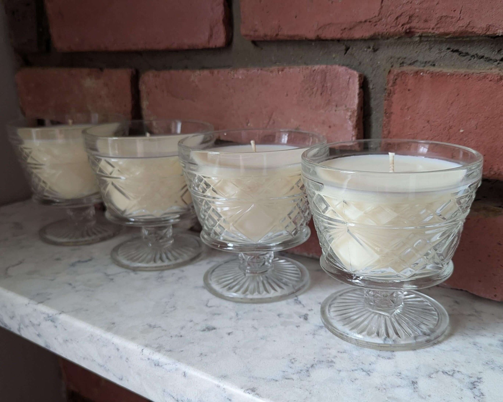 Hand-poured coco-soy wax blend candles in clear glass holders, perfect for elegant home decor.