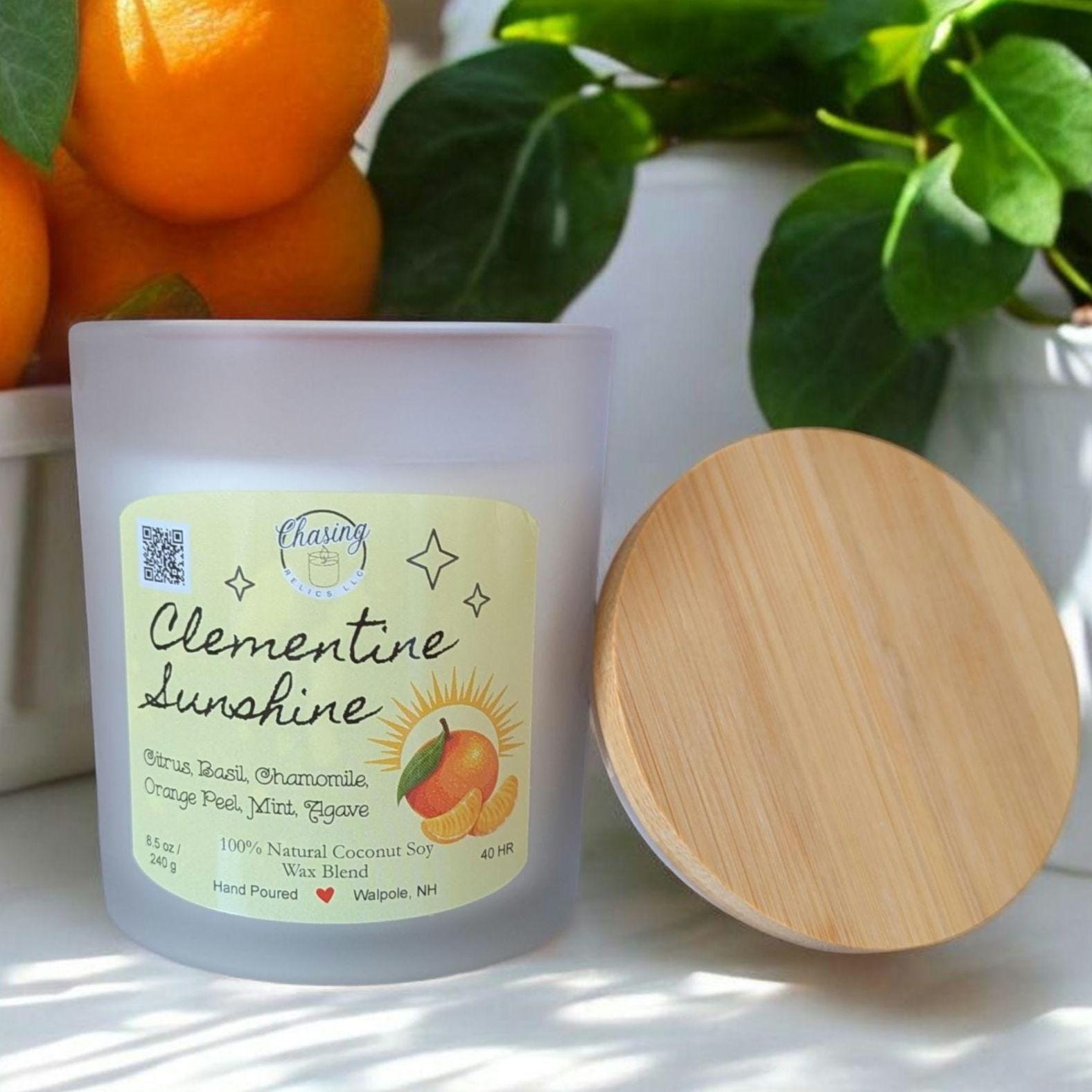 Hand-poured Clementine Sunshine candle with citrus slice wax top, made from 100% natural coconut soy wax, displayed with a bamboo lid.